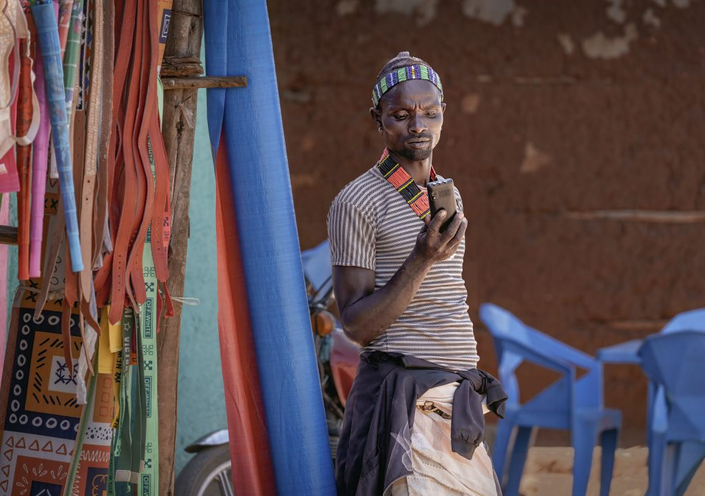 man and phone at the market in key afer kopie