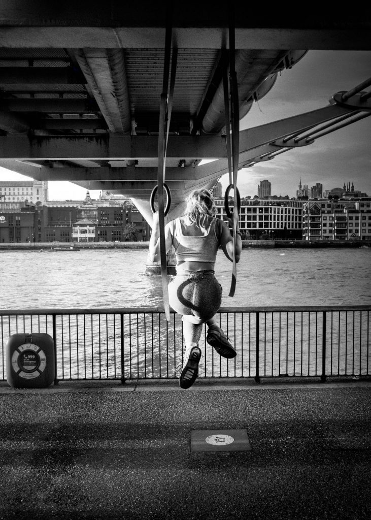 gymnast on rings under the millenium bridge