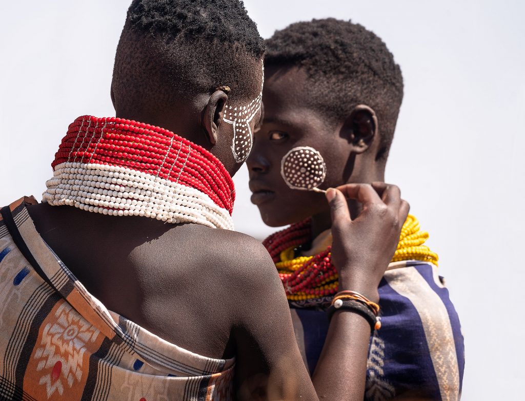 karo woman painting her friend